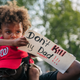 A child sits on his farther’s shoulders at a protest over the police shooting of Jacob Blake in Kenosha, Wis.